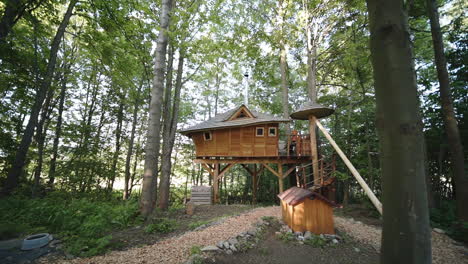 Dolly-zoom-FHD-shot-of-a-luxurious-wooden-tree-house-accommodation-with-a-neat-campsite-in-a-forest-in-Dolní-Morava,-Czech-Republic