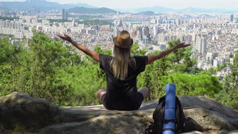 Mädchen-üben-Yoga-Lotus-Pose-Und-Meditieren-Am-Rande-Eines-Berges-Mit-Blick-Auf-Die-Skyline-Vom-Gwanaksan-Berg-In-Südkorea