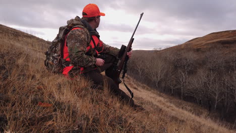 A-hunter-looks-for-prey-through-his-binoculars-near-Saskatchewan,-Canada