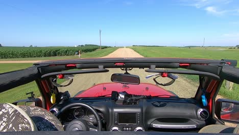POV-Driving-on-graveled-road-in-rural-South-Dakota-between-fields-and-towards-a-flooded-pond