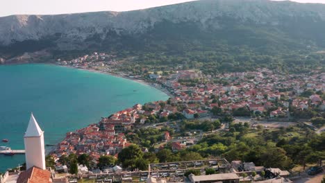 Scenic-Architectures-Of-Resort-And-Beaches,-Churches,-Old-Town-Of-Baska-By-The-Coastal-Mountains-Near-The-Calm-Blue-Sea-From-The-Sveti-Jurje-ChurchAnd-Cemetery-In-Krk-Island,-Croatia