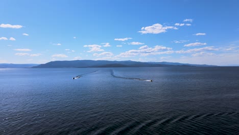 Flathead-Lake:-speedboats-crossing-water-in-Kalispell,-Montana,-aerial-view