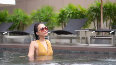 Attractive-Woman-Sitting-in-Bubbling-Hotel-Swimming-Pool