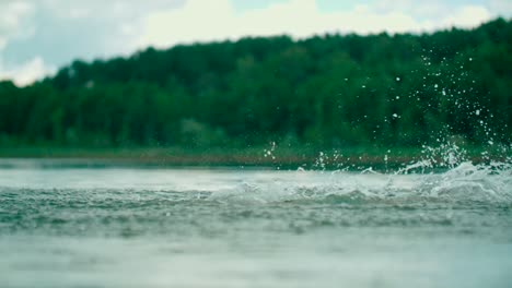 Joyful-little-boy-making-splashes-in-the-water-and-having-fun-in-the-lake
