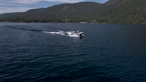 Orbit-shot-of-Wakeboarder-and-tow-boat,-Flathead-Lake,-Montana