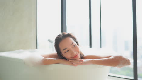 Mujer-Asiática-Satisfecha-Disfrutando-De-Un-Relajante-Baño-De-Espuma