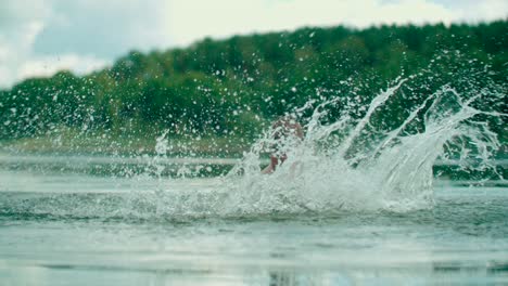 A-joyful-Caucasian-kid-splashes-the-water-in-the-lake