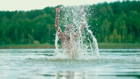 A-child-makes-splashes-while-standing-in-a-freshwater-lake-with-a-nature-background