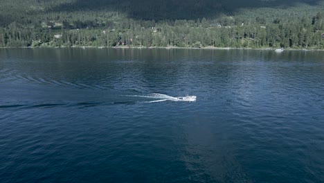 Wakesurfing-Adventure-At-The-Dark-Blue-Flathead-Lake-In-Montana-On-A-Bright-Summer-Day---aerial-drone