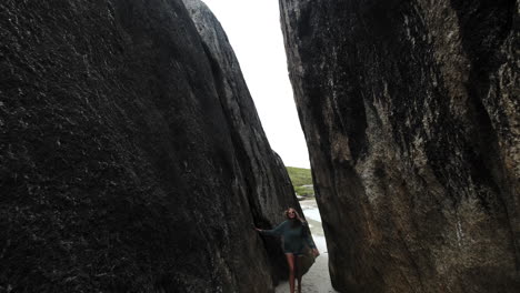Slowmotion-backward-shot-of-young-girl-walking-between-rock-formation-outdoor-in-nature