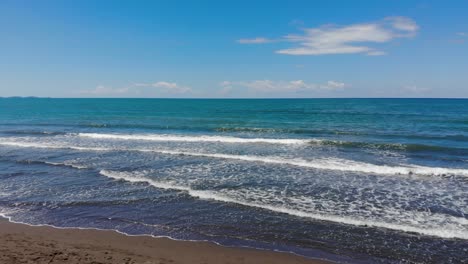 White-waves-of-turquoise-sea-splashing-on-sandy-beach-on-a-wild-seaside-in-Adriatic-seaside,-Albania