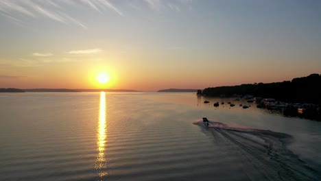 Water-skiing-on-lake-Geneva,-Wisconsin-during-golden-hour-from-a-aerial-view