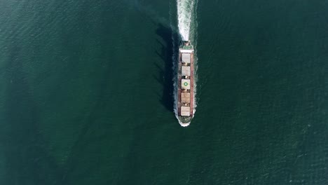 Top-down-aerial-footage-of-a-Cargo-ship-cruising-in-Hong-Kong-bay