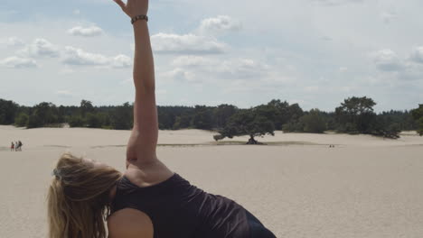 Beautiful-woman-raising-right-arm-while-doing-yoga-exercises