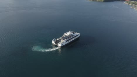 A-Ferry-Boat-Cruising-In-Slow-Motion-Over-The-Calm-Blue-Sea,-Leaving-The-Port-In-The-Philippines-On-A-Sunny-Day---Aerial-Drone-Shot,-Orbiting-Shot