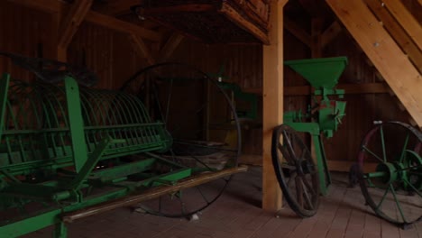 Panning-view-of-old-green-soil-cultivator-in-barn