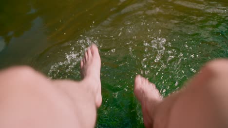 Close-up-view-barefoot-playing-on-freshwater-lake-river-and-splashing-water