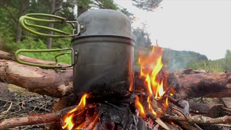 Cooking-pot-on-flaming-campfire,-Highlands,-Scotland