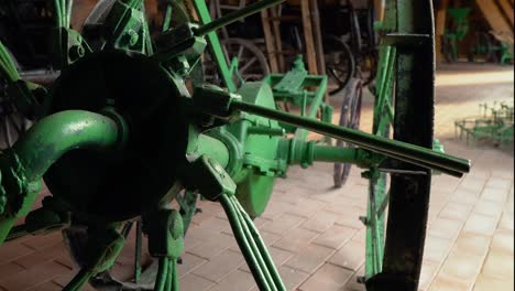Male-hand-rotating-piece-of-green-coloured-vintage-agricultural-equipment