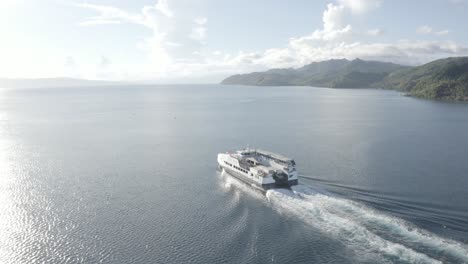 Ein-Passagier-Fastcat-Fährboot,-Das-Auf-Dem-Ruhigen-Blauen-Ozean-Gegen-Warmes-Sonnenlicht-In-Liloan,-Southern-Leyte,-Philippinen,-Kreuzt-Und-Kielwasser-Hinterlässt---Drohnenaufnahme-Aus-Der-Luft