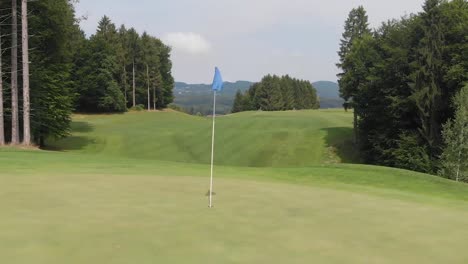 Dolly-zoom-of-a-blue-golf-flag-on-a-golf-course