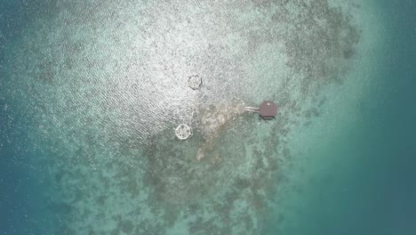 Top-down-blick-Auf-Ein-Luxus-cottage-resort-Inmitten-Eines-Kristallklaren-Blauen-Wassers-Auf-Der-Tropischen-Insel-Der-Philippinen-Bei-Hellem-Wetter