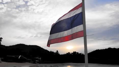 Thailändische-Flagge-Weht-Bei-Sonnenaufgang-Im-Wind-Gegen-Den-Himmel-Am-Mataphon-Pier-In-Thailand