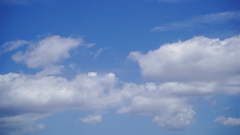 Flauschige-Weiße-Wolken,-Die-Sich-Am-Nachmittag-Am-Strahlend-Blauen-Himmel-Bewegen---Zeitraffer