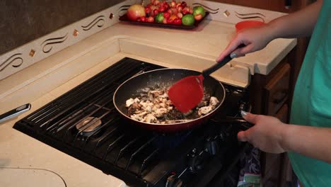 Woman-sauteing-maitake-mushrooms-with-bubbling-butter-in-a-skillet-in-a-tiny-home-kitchen