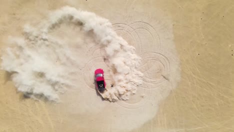 Drone-looking-down-on-a-red-truck-doing-high-speed-doughnuts-in-the-desert,-kicking-up-dust