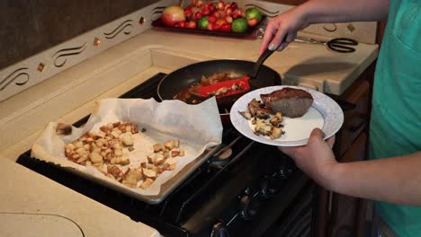 Frau,-Die-Steak,-Gegrillte-Zwiebeln,-Sautierte-Miatake-Pilze-Und-Bratkartoffeln-In-Einer-Kleinen-Küche-überzieht