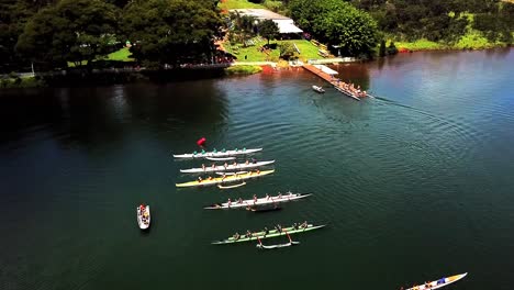 Aerial-view-above-lakeside-jetty-rowing-teams-preparing-for-lake-water-sport-practice-racing