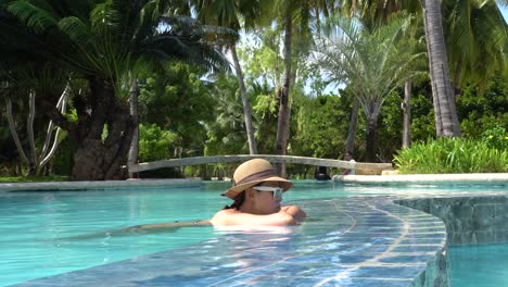 Una-Hermosa-Mujer-Relajándose-En-La-Piscina-Del-Resort-Dos-Palmos-Island-En-Puerto-Princesa,-Palawan,-Filipinas---Toma-De-Bajo-Nivel