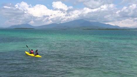 Un-Par-De-Turistas-Que-Usan-Un-Chaleco-Salvavidas-Y-Kayak-En-El-Océano-Tropical-Cerca-Del-Resort-Dos-Palmas-Island-En-Honda-Bay,-Puerto-Princesa,-Palawan,-Filipinas