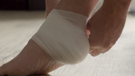 Ankle-wrapped-in-bandages-and-bandage-being-tied-up