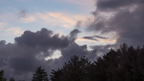 Sonnenuntergang-Im-Zeitraffer,-Dunkle-Wolken-Rollen-Heran-Und-Bedecken-Den-Bunten-Himmel-über-Dem-Wald