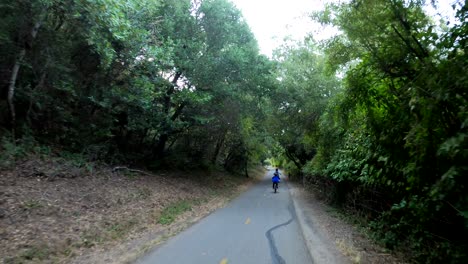 Mom-and-son-speeding-through-an-empty-bike-trail-in-the-forest