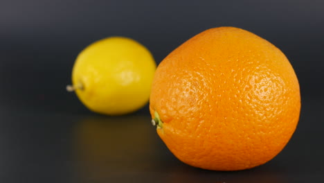 Orangenfruchtfokus-Vs.-Zitrone-Im-Hintergrund,-Zitrusfrüchte,-Lebensmittel,-Frisch,-Saftig,-Vitamin,-Gemüse,-Makro-Studioaufnahmeillustration,-Ernährung,-Buntes-Dessert,-Nahrungsmittelfrüchte
