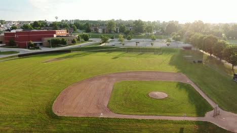 Aerial-truck-shot-of-baseball-field-of-dreams-during-morning-sunrise-at-public-school-grounds-in-United-States