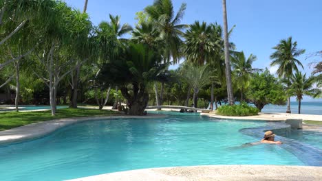 Turistas-Disfrutando-Del-Verano-En-La-Acogedora-Piscina-Al-Aire-Libre-En-Dos-Palmos-Island-Resort-En-Puerto-Princesa,-Palawan,-Filipinas---Plano-Medio