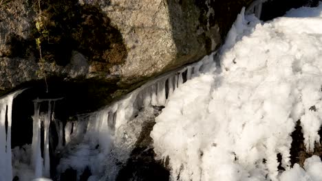 Unter-Einem-Großen-Granitfelsen-Entspringt-Ein-Kleiner-Wasserfall-Aus-Einer-Eisschicht