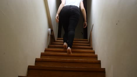 Woman-walks-up-a-dark-staircase-at-night