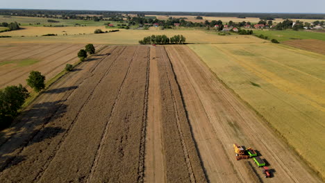 Aerial-Drone-Shot-Of-A-Combine-Harvester-Loading-A-Truck-In-A-Field-during-sunny-day