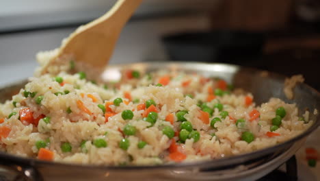 Rühren-Von-Gebratenem-Reis,-Während-Er-Mit-Erbsen-Und-Karotten-Auf-Dem-Wok-Kocht---Zeitlupe