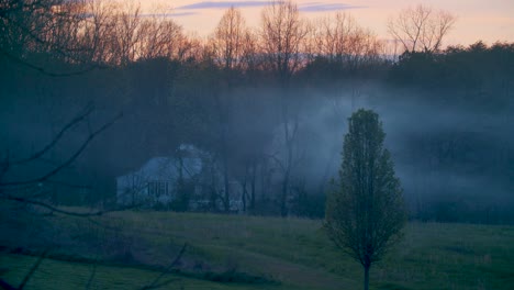 Ein-Schöner-Klarer-Sonnenuntergang-Des-Frühen-Frühlings-Auf-Dem-Land,-Ein-Haus-Kennzeichnend,-Das-Rauch-Im-Hintergrund-Freisetzt