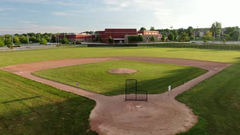 Baseball-diamond,-athletic-fields-with-American-school-in-Pennsylvania-USA-during-magic-hour,-sports-season-cancelled-due-to-Coronavirus-COVID