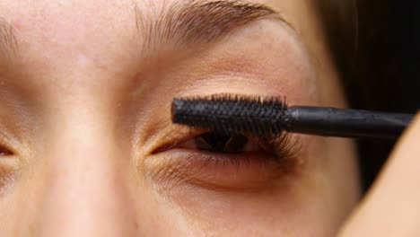Woman-applies-mascara-to-her-eye-lashes