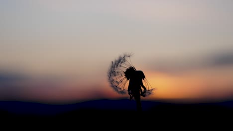 A-person-blows-in-a-dandelions-blowball-which-is-in-front-of-a-beautiful-sunset