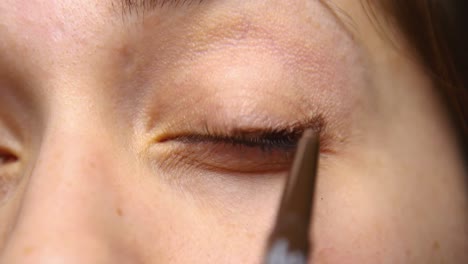 Woman-applies-eyeliner-to-her-upper-lid