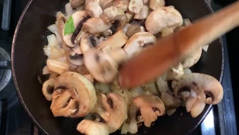 Pilze-Und-Zwiebeln-über-Einer-Gusseisernen-Pfanne-Kochen